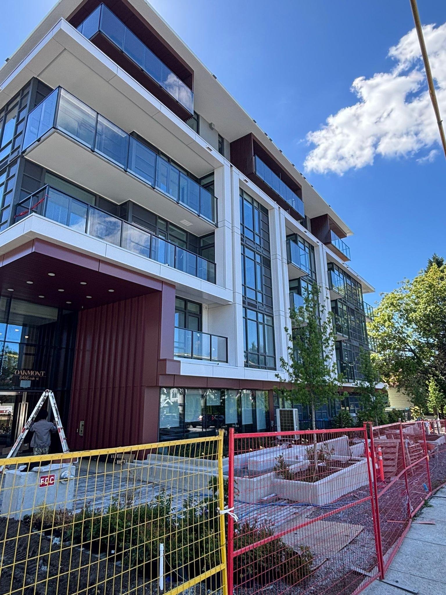 Oakmont main entrance with custom deep-red ACM column and fascia cladding
